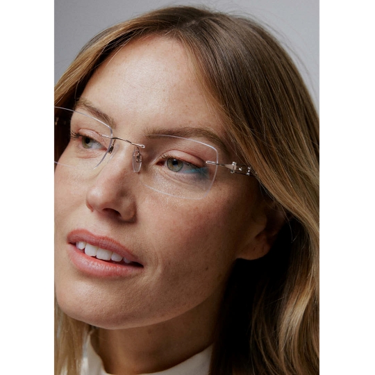 Close-up photo of woman wearing rimless Line Art CHARMANT eyeglasses.