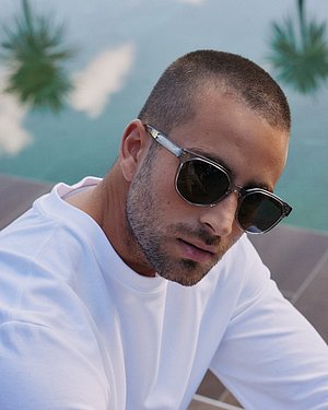 Foto eines männlichen Models bei einem Pool, das eine Esprit-Sonnenbrille trägt.